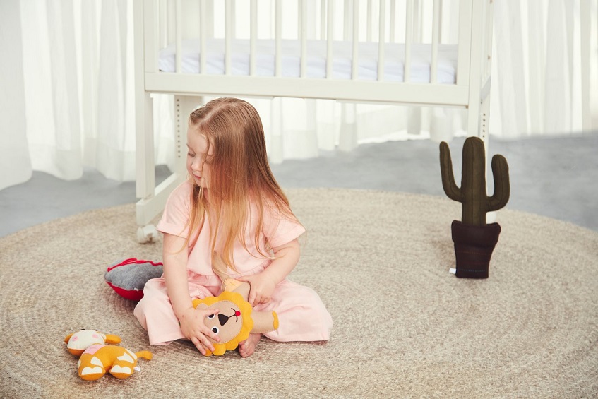 Girl sitting on floor with plush toys