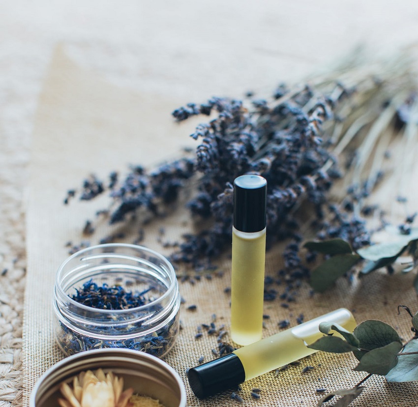 picture of lavender oil beside a fresh lavender 