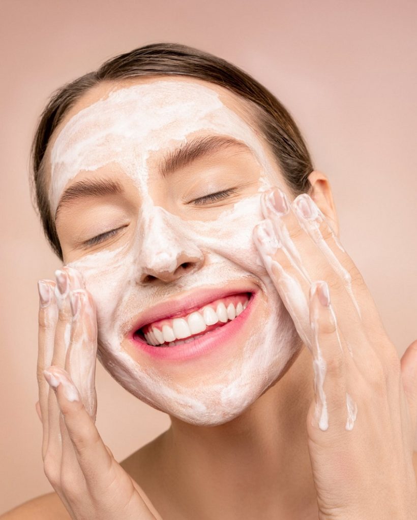 picture of a woman washing her face with a foam 