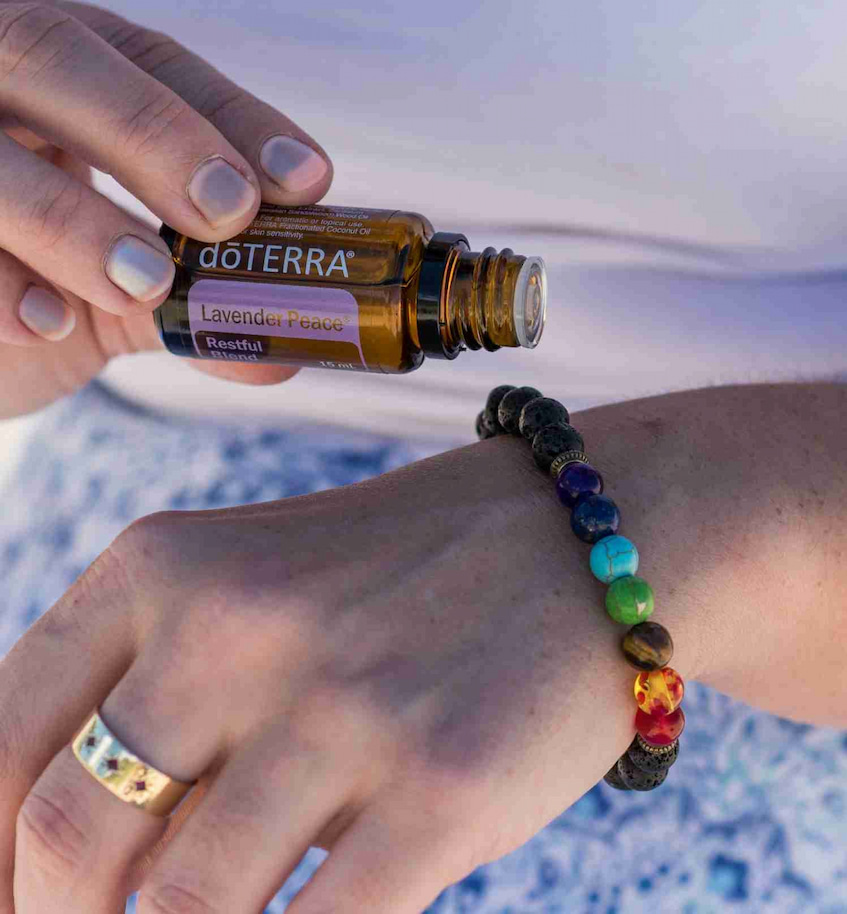 girl drips doTerra essential oil on bracelet
