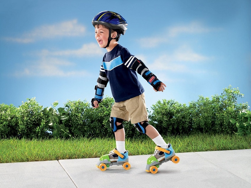 picture of a little kid driving roller skates on a sidewalk with protective gear 