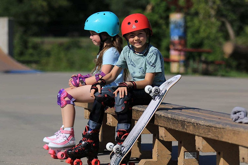 picture of two kids with roller skates and a skateboard in the park