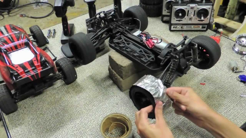 Man changing the tires on RC drift car