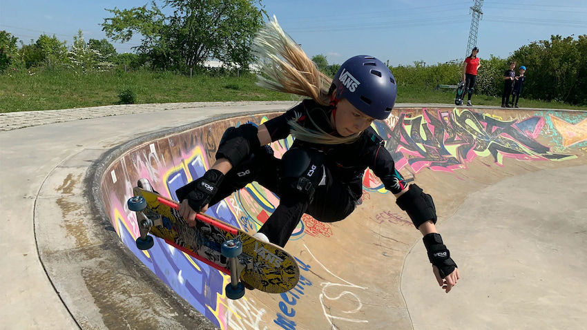 girl skating with her dark blue skate helmet