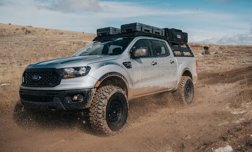 Silver Ford Ranger with load driven off road